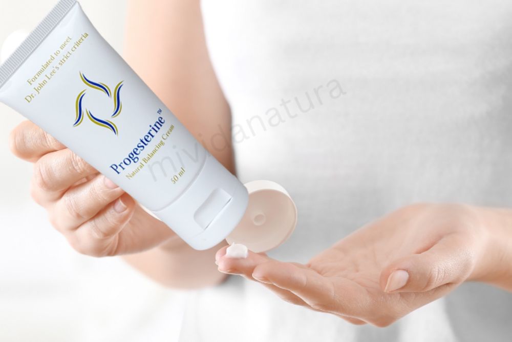 woman with white dress squeezing progestrine cream